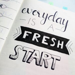 Notebook page featuring motivational quote 'Everyday is a fresh start' with colorful pens.