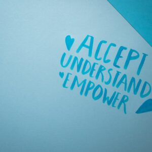 Blue background featuring handwritten words promoting acceptance, understanding, and empowerment.